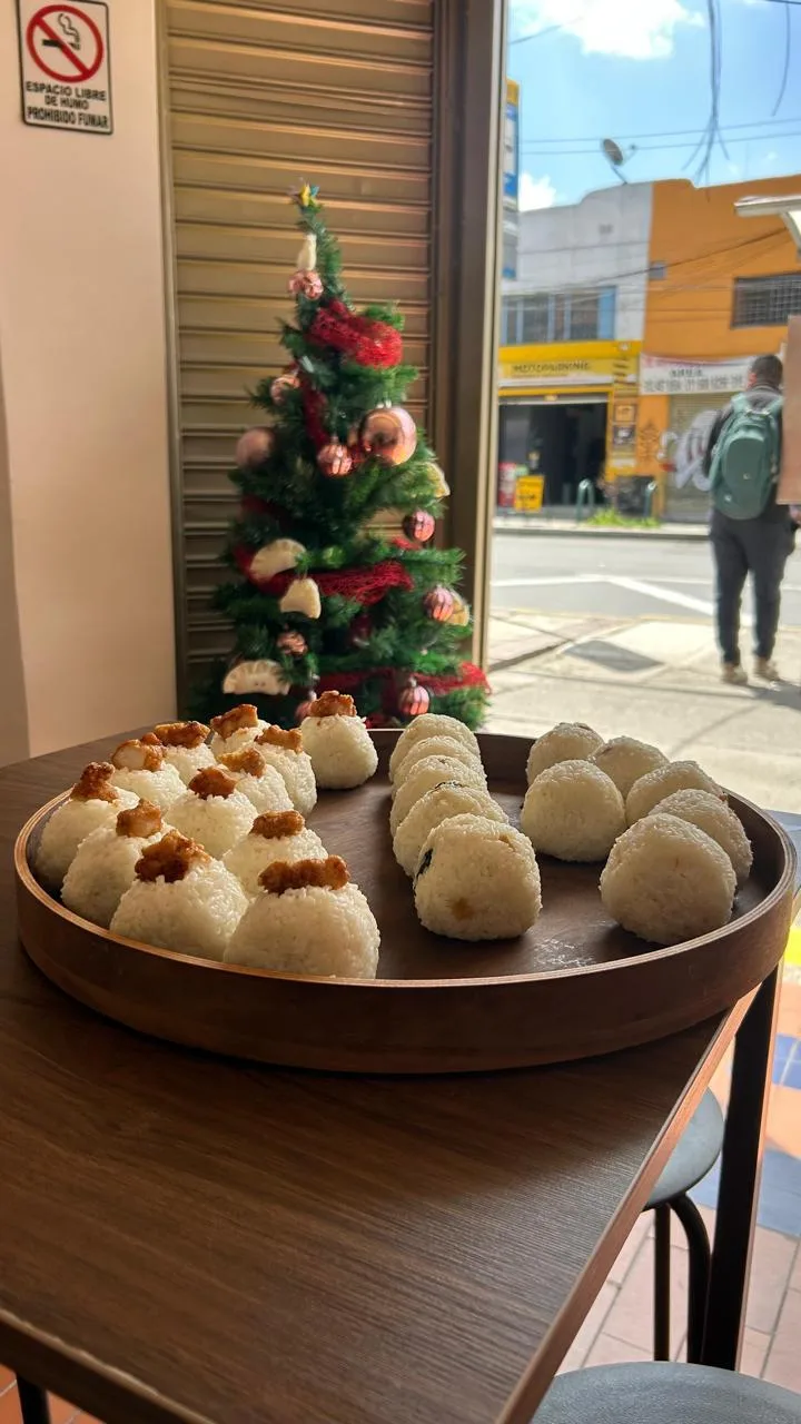 Bandeja de onigiri en una mesa junto a la ventana que da a la calle